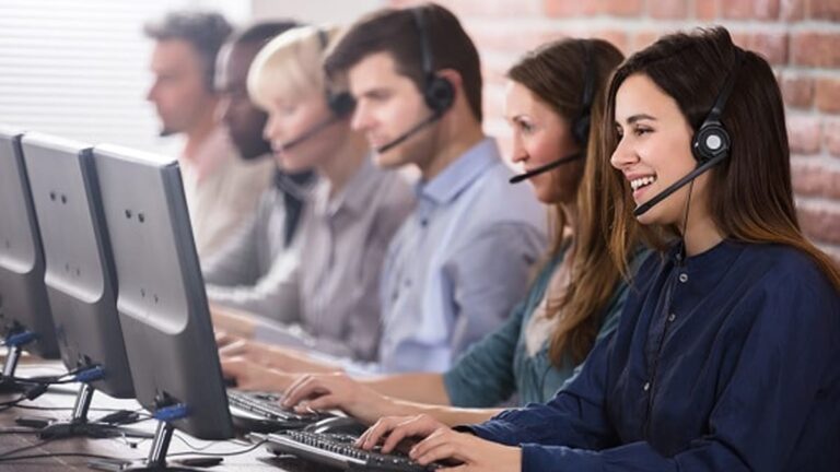 امرأة تبتسم وتعمل في مركز للاتصالات.