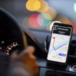 لوحة قيادة سيارة بهاتف يعرض خريطة وتطبيق نقل ذكي.