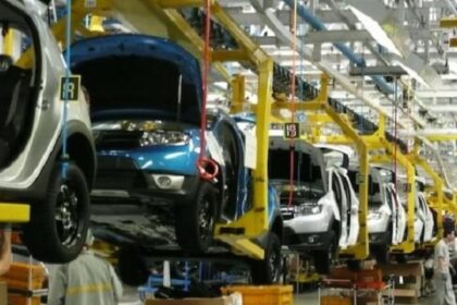 سيارة زرقاء داخل مصنع حديث لإنتاج السيارات.