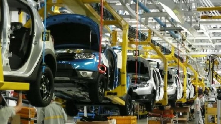 سيارة زرقاء داخل مصنع حديث لإنتاج السيارات.