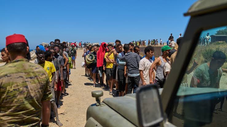 مجموعة من الأشخاص يمشون على طريق تحت أشعة الشمس