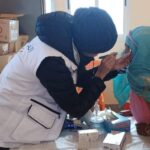 امرأة تحقن طفلاً بإبرة طبية
