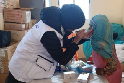امرأة تحقن طفلاً بإبرة طبية