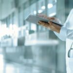 طبيب يعاين ملفاً طبياً رقمياً على جهاز آيباد
