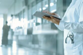 طبيب يعاين ملفاً طبياً رقمياً على جهاز آيباد