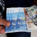 أوراق نقدية للدولار الأمريكي والدرهم المغربي معروضة.