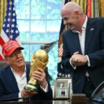 دونالد ترامب يتحدث وخلفه رجال يحملون كأسًا