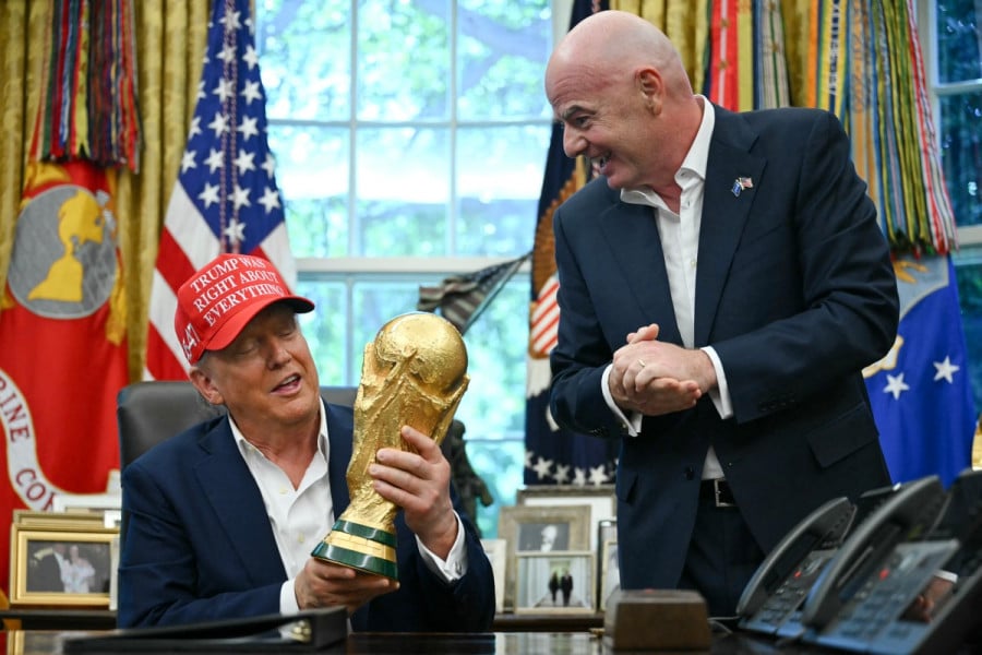 دونالد ترامب يتحدث وخلفه رجال يحملون كأسًا