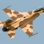 طائرة مقاتلة من طراز F-16 تحلق في السماء، تظهر قوة الأسطول الجوي.