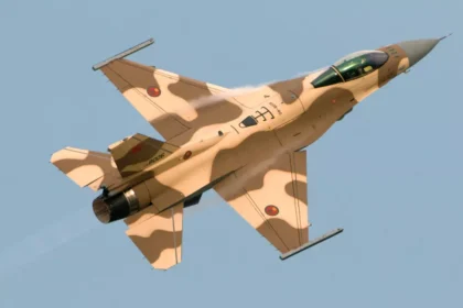 طائرة مقاتلة من طراز F-16 تحلق في السماء، تظهر قوة الأسطول الجوي.