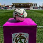 كرة قدم على أرضية الملعب مع شعار النادي