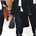 أشخاص يرتدون ملابس رسمية ويمسكون حقائب يدوية يمشون معًا.