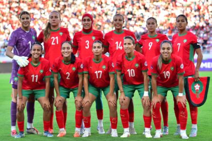 لاعبات كرة قدم فرنسيات بالزي الرسمي ينظرن إلى ملعب عشبي