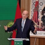 جياني إنفانتينو يتحدث أمام شعار الفيفا وخلفية