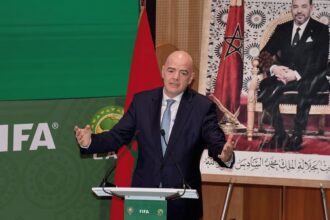 جياني إنفانتينو يتحدث أمام شعار الفيفا وخلفية