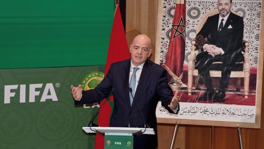 جياني إنفانتينو يتحدث أمام شعار الفيفا وخلفية