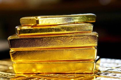 قضبان ذهبية مكدسة فوق طاولة داكنة