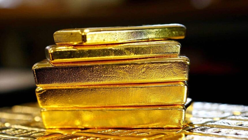 قضبان ذهبية مكدسة فوق طاولة داكنة