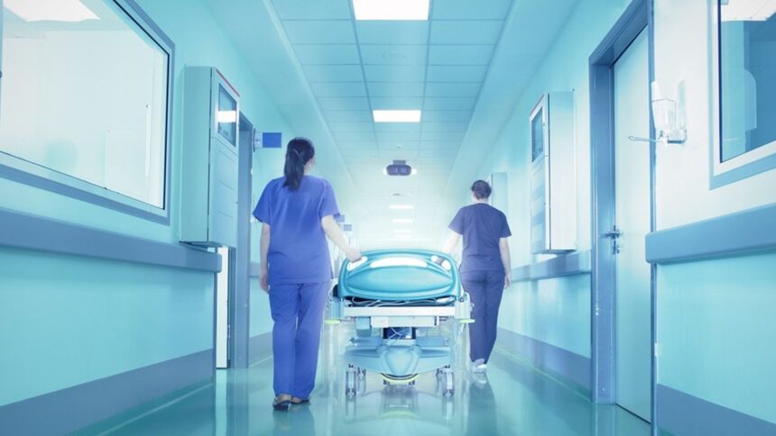 ممرضون يحملون مريضًا في غرفة مستشفى