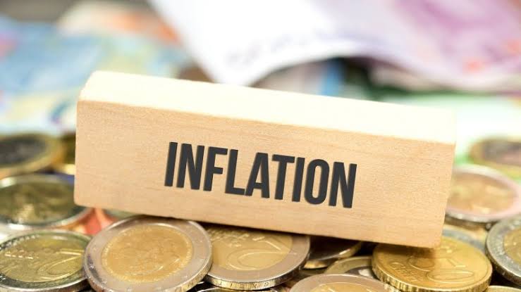 مكعبات خشبية تحمل كلمة "تضخم" مع عملات معدنية.