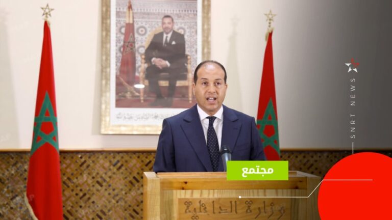 متحدث رسمي ببدلة زرقاء أمام منصة إعلامية
