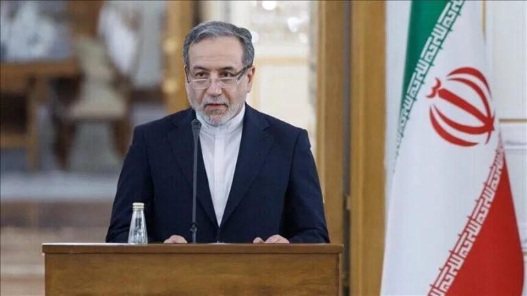 وزير إيراني يتحدث من منبر أمام علم بلاده
