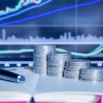 قلم وأوراق مالية مع رسوم بيانية لسوق المال.