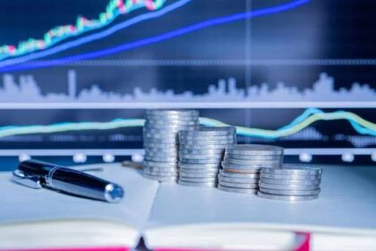 قلم وأوراق مالية مع رسوم بيانية لسوق المال.