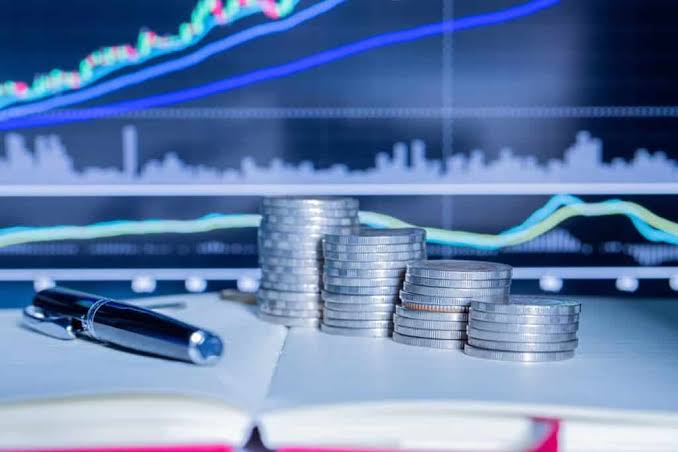 قلم وأوراق مالية مع رسوم بيانية لسوق المال.
