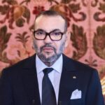 الملك محمد السادس يلقي خطابًا رسميًا ببدلة أنيقة.
