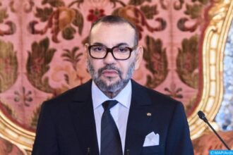 الملك محمد السادس يلقي خطابًا رسميًا ببدلة أنيقة.