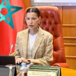 الأميرة للا مريم وخلفها علمان، تتحدث في مناسبة رسمية.