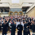 محامون يرتدون الزي الرسمي أمام مبنى المحكمة