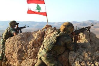 جنديان لبنانيان مدربان يقفان خلف الصخور