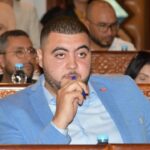 رجل يرتدي بدلة زرقاء يمسك بقلم في يده