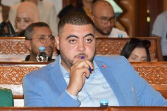 رجل يرتدي بدلة زرقاء يمسك بقلم في يده