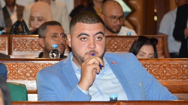 رجل يرتدي بدلة زرقاء يمسك بقلم في يده