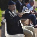 رجل يجلس على مكتب ويدرس وثائق مالية مهمة.