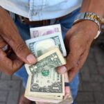 رجل يحمل أموالاً متنوعة في سوق.