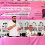رجل يتحدث في ميكروفون أمام خلفية وردية.