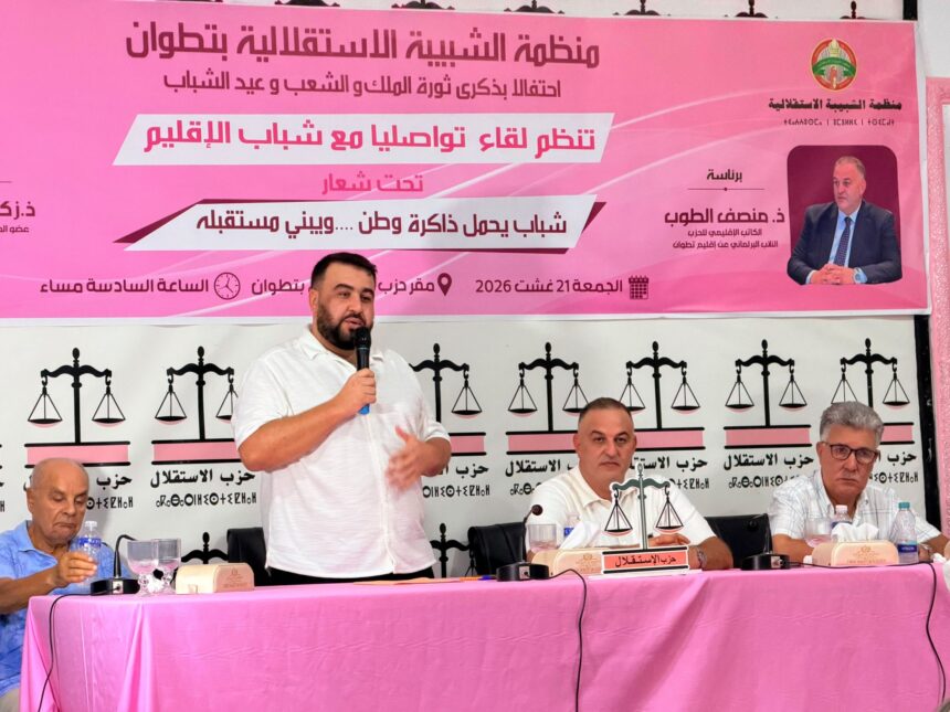 رجل يتحدث في ميكروفون أمام خلفية وردية.