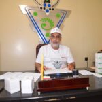 رجل يجلس أمام أوراق وقلم أصفر لافتة