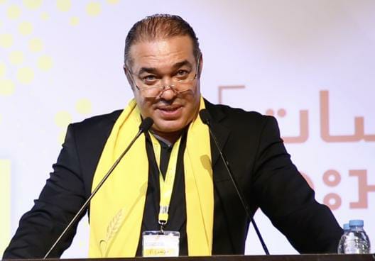 رجل يرتدي بدلة يتحدث في الميكروفونات