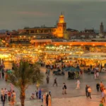 سوق مراكشي صاخب وقت الغروب أمام مسجد