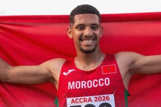 عداء مغربي يحمل علم المغرب ويحتفل بالفوز