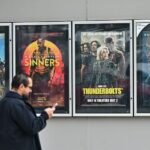 أشخاص أمام ملصقات أفلام، أحدهم يظهر صامويل جاكسون