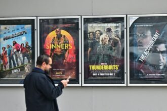 أشخاص أمام ملصقات أفلام، أحدهم يظهر صامويل جاكسون