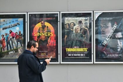 أشخاص أمام ملصقات أفلام، أحدهم يظهر صامويل جاكسون