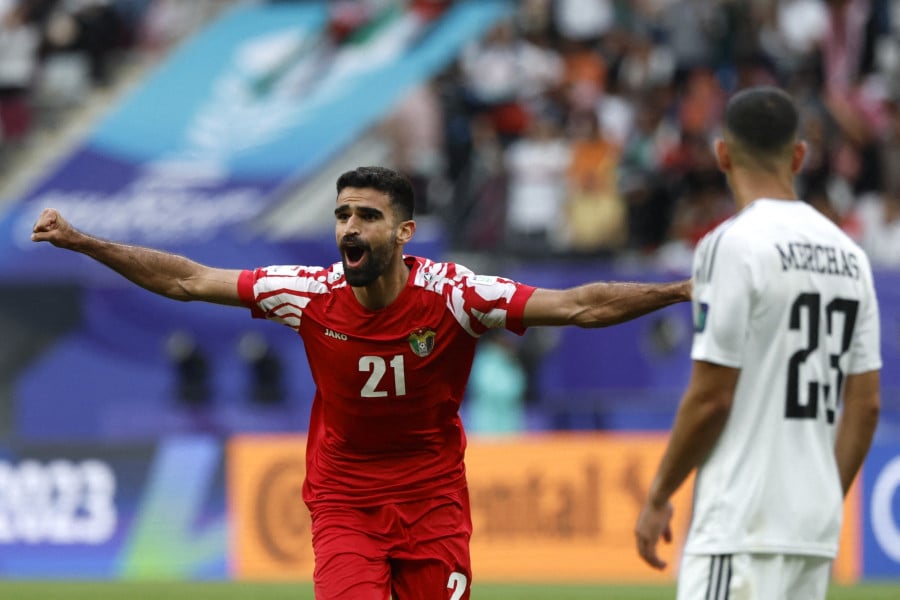 نزار الرشدان بقميص أحمر وأبيض يحمل الرقم 21.