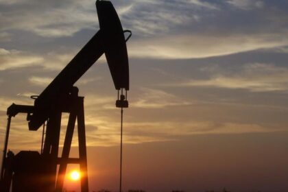 أبراج تكرير النفط تظهر بوضوح في الأفق عند غروب الشمس.